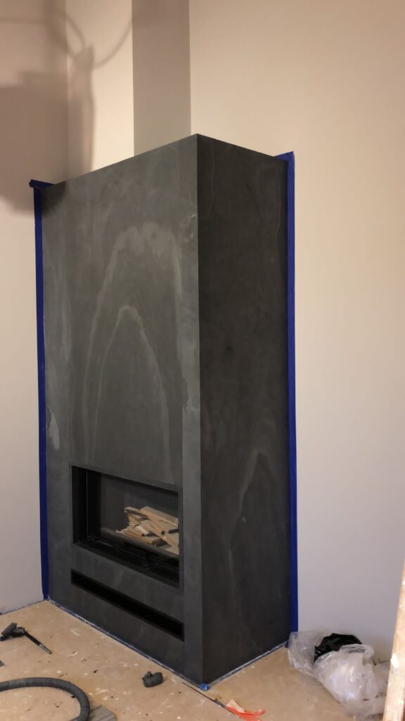 Realizacja obudowy kominka fornirem kamiennym Black Stone